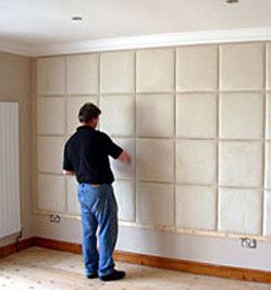 a man putting up padded wall tiles Padded Wall Panels, Mom Bedroom, Fabric Wall Panels, Upholstered Wall Panels, Wall Panels Bedroom, Storage Solutions Bedroom, Bed Headboard Design, Upholstered Walls, Art Walls