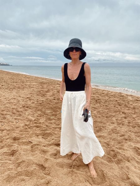 Looks With Hats Summer, Summer Sun Protective Outfits, Black Beach Hat Outfit, Black Bucket Hat Outfit Summer, Minimalist Beach Outfit, Black Bucket Hat Outfit, Beach Hats Outfit, Black Hat Outfit, Tkees Sandals