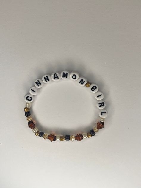 handmade lana del rey cinnamon girl beaded bracelet 🐕. made with 4mm and 6mm bicone crystal gems, 4mm colored beads, and white letters on elastic string. message with any comments,questions, or concerns 🤍. Lana Del Ray Bracelet, Lana Del Rey Beaded Bracelet, Lana Del Rey Friendship Bracelet, Lana Clothes, Ldr Bracelets, Lana Del Rey Bracelet, Lana Bracelet, Braclets Diy, Clay Bead Bracelet Ideas