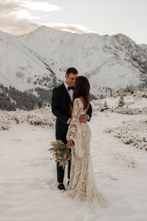 Bride and groom stand in the snow with snowy mountains in the background during sunrise for their elopement. Alaskan Wedding Dress, Colorado Winter Wedding Elopement, Aspen Elopement Winter, Mountain Snow Wedding, Mountain Elopement Dress Winter, Bridal Alpine Aesthetic, Snow Mountain Wedding, Winter Colorado Elopement, Winter Wedding Pictures Outdoor