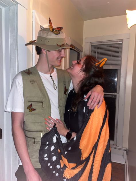 A couple wearing a butterfly costume and a bug catcher costume. Bug catcher is wearing a beige vest with a safari hot with butterflies pinned on. The butterfly is wearing a black dress with black tights and a pair of monarch wings Ladybug And Bug Catcher Costume, Butterfly Catcher And Butterfly Costume, Hollow Web Costume Ideas, Couples Butterfly Costume, Bug And Bug Catcher Costume, Bee And Bee Keeper Costume Couple, Butterfly And Bug Catcher Costume, Zoo Keeper Couple Costume, Bee Catcher Costume