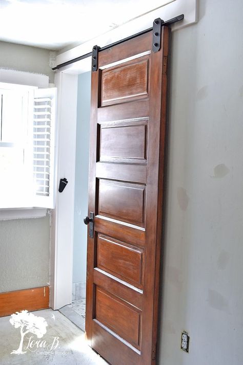 Old house bathrooms are usually space challenged. Ours also had low ceilings, too. A low clearance barn door/ sliding door mechanism was a great option to solve both of the issues. Using a vintage door kept the old house character, and the slider improved the functionality. Here's how we did it. Choose a Vintage Door and Refinish to your Style    We found a 5 panel old door. The stain was kind of orange, so I sanded it down and stained it with a darker brown stain. A coat of water base… Sliding Door Mechanism, Mirror Barn Door, House Character, Barn Door Pantry, Door Mechanism, Barn Door Sliding, Double Sliding Barn Doors, Building A Barn Door, Bifold Barn Doors