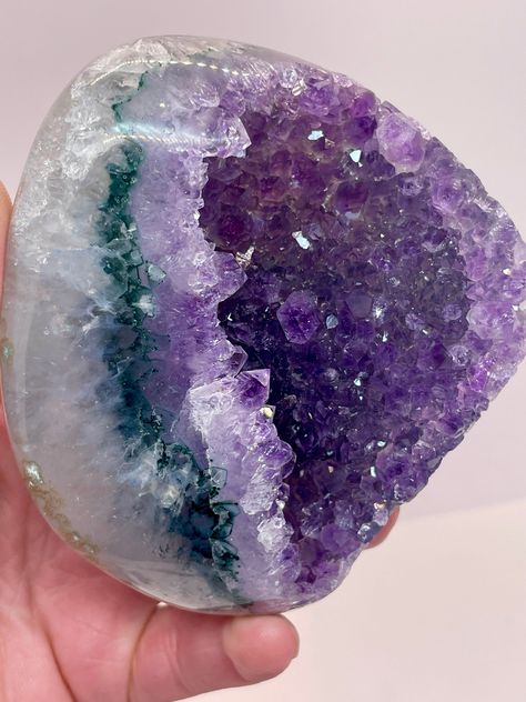 A gorgeous, solar eyed Uruguay Amethyst that's raw in the center and polished on the sides! An amazing, top quality color Amethyst with insane shine and a green/teal layer between the rainbow shine and the Quartz base colors! In this specimen you get a cross of raw and polished with icy purple rainbow colors and free standing crystals inside the mouth of the crystal. There is a ton of inclusions and deposits of minerals inside the Quartz base!  Amethyst clusters from Uruguay are known to be the top-pest of quality! Please let me know if you have any questions. All sales final, no returns or refunds. Follow my lapidary journey @mercsminerals on IG and TikTok! Size: 97x82mm and 427 grams ( almost a pound of beauty!) Aura Quartz Cluster, Rainbow Aura Quartz, Purple Rainbow, Rock City, Purple Quartz, Crystal Therapy, Crystal Geode, Crystal Magic, Amethyst Cluster