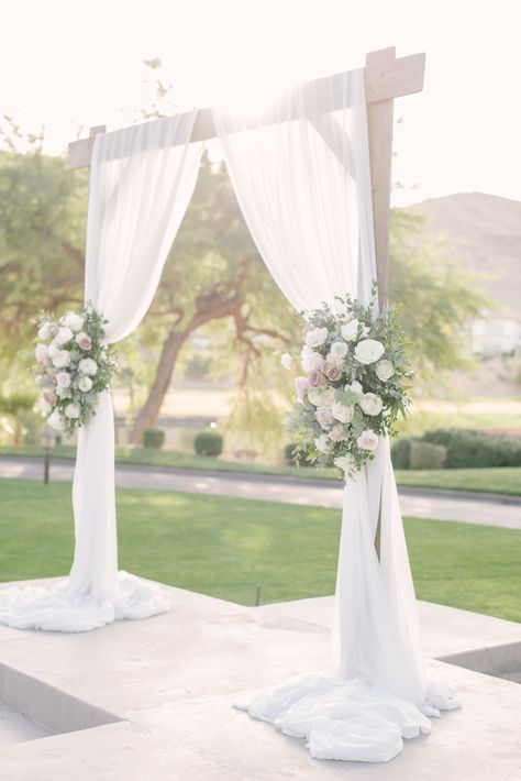 Wooden square wedding arch with white draping and two large spring flower pieces with blush, ivory, and lavender flowers.  Large tree and greenery background.  #lasvegasweddingvenue #woodarch #microweddingslasvegas July Wedding Colors, Flower Arch Wedding, Wood Wedding Arches, Wooden Wedding Arches, White Wedding Arch, Most Beautiful Flower, Draping Wedding, Wedding Archway, White Bridal Gown