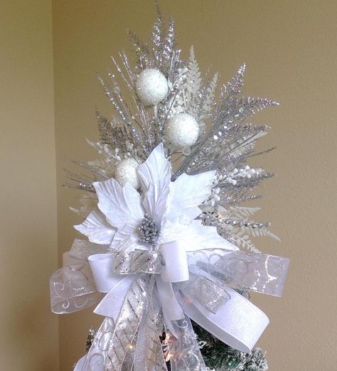 READY TO SHIP *One of a kind will not be recreated this Season* ~~You will receive exact item in listing~~  BOW IS INCLUDED RESHAPING OF BOW/ RIBBON MAY BE NECESSARY AFTER SHIPPING This elegant Christmas Velvet Poinsettia Tree Topper is ready to make your home stand out this holiday season! Gorgeous Velvet Poinsettia Tree Topper features a large Velvet White/Silver Poinsettia with silver glittery center surrounded by 3 White glittery snowball spray, Silver glittery sprays, white glittery sprays, white glittery berries and  faux jeweled spray and silver ball strain spray complete this beautiful tree topper. Tree Topper measures approx: Height 17 inches and  Width 16 inches without bow. Bow measures approx. 18 inches wide and streamers measuring over 2 feet long. This is a one sided tree top Tree Topper Ideas, Silver Tree Topper, Poinsettia Tree, Xmas Tree Toppers, Christmas Velvet, Christmas Elegant, Tree Topper Bow, Christmas Tree Decorations Diy, Winter Tree