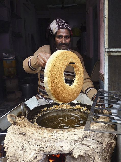 Ghevar (Devanagari:घेवर) is a Rajasthani sweet traditionally associated with the Teej Festival. It is disc-shaped, and made from oil, flour and sugar syrup. There are many varieties of Ghevar, including plain, mawa and malai ghevar.   - Explore the World with Travel Nerd Nici, one Country at a Time. http://TravelNerdNici.com Rajasthani Street Food, Malai Ghevar, World Street Food, Teej Festival, Desi Street Food, Street Food Market, Amazing India, World Street, India Culture