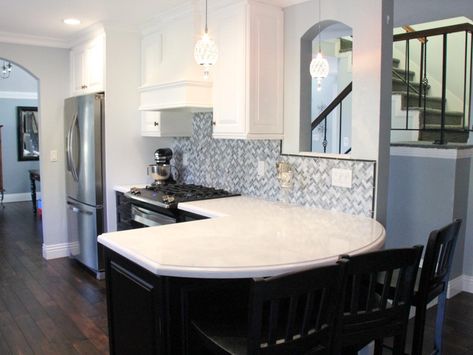 The curved peninsula in this transitional kitchen creates the perfect eat-in bar. The white and black cabinets and gray backsplash create an elegant feel in the space. The rich wood floors also allow this kitchen to feel warm and inviting. Peninsula Kitchen Ideas, White Traditional Kitchen, White Transitional Kitchen, Curved Kitchen Island, Peninsula Kitchen, Open Concept Kitchen Living Room, Curved Kitchen, Kitchen Peninsula, Grey Backsplash