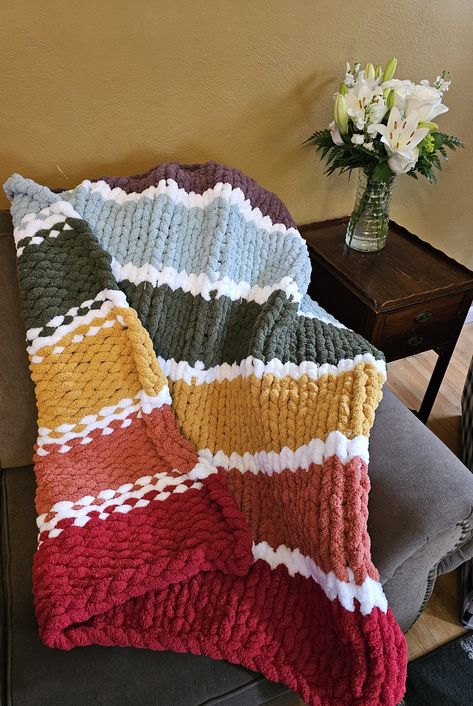 Celebrating Love is Love! Wrap yourself in the luxurious warmth of our handmade Chunky 40x50 Blanket, knitted with soft and snuggly Chenille yarn. This oversized blanket is perfect for those cozy moments on the couch, reading a book, or watching your favorite movie. The chunky knit design adds a touch of texture and style to any room, making it a must-have addition to your home decor. Whether you're looking for a warm and comforting gift or a treat for yourself, our Chunky Blanket is the perfect choice. Indulge in the ultimate comfort with this beautifully crafted, hand-knitted creation. *PLEASE NOTE: Measurements may vary slightly due to the handmade nature of all products to the natural shift in yarn. **Cleaning Instructions : Machine wash cold on delicate cycle, Lay flat to dry or Tumbl