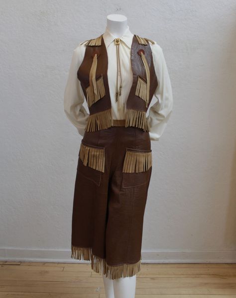 "Incredible 1940's leather western outfit! - 1940's - No tags - Vest and split-skirt - Two tone leather - Fringe trim Vest - No closures - Fringe along shoulders, front of vest, and hem Split Skirt/Gauchos - Fringe along faux pockets and hem - Wide leg - Adjustable lace up tie on back Measurements: *The mannequin photographed has a 33\" bust, 24 1/2\" waist, and 34 1/2\" hips. Vest - Bust: lying flat approx. 33 1/2\", up to approx. 36\" - Shoulders: 11\" - Shoulder to hem: 15\" - Fringe: 2 3/4\" Leather Western Outfit, 70s Western Fashion, 1940s Fashion Women, Fringe Clothing, Vintage Western Wear, Western Vest, Sweater Skirt Set, Billings Mt, Poodle Skirt