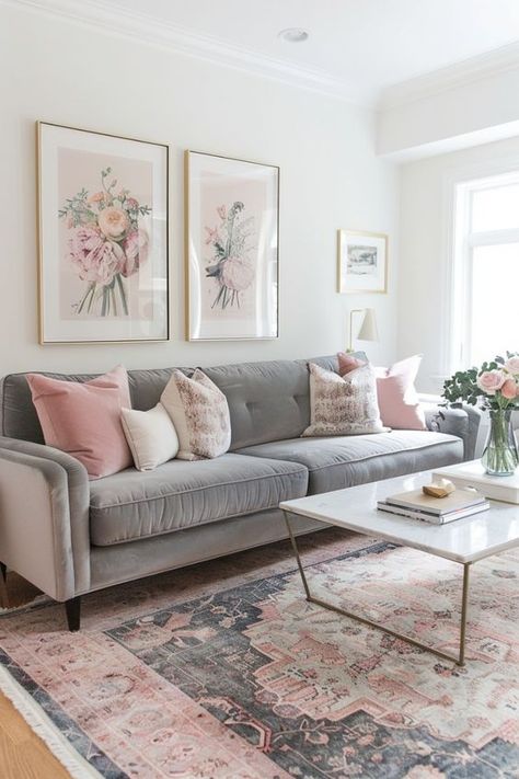 A grey velvet couch with pink throw pillows and a blush area rug brings soft glamour to the living room. The combination of textures and subtle colors creates a warm and inviting atmosphere. Click to see more. Grey Couch Apartment Living Room Ideas, Pink And Grey Apartment Decor, Blush Pink And Grey Living Room, Grey And Blush Pink Living Room, Gray Pink Living Room, Living Room Designs Gray Couch, Grey Pink Living Room, Pink Gray Living Room, Gray And Pink Living Room