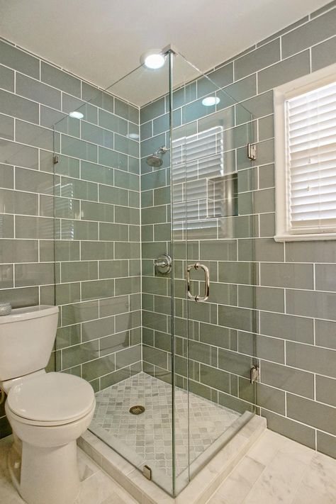 This sleek master bathroom features a glass enclosed shower paired with gray tiled walls. Gray and white marble floors offer a finishing touch. Glass Enclosed Showers, Grey Bathroom Tiles, Marble Floors, Bathroom Features, Storage Inspiration, Transitional Bathroom, Bathroom Tile Designs, Shabby Chic Bathroom, Chic Bathrooms