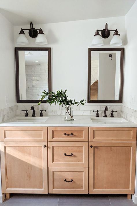 This bathroom remodel includes his and her sinks with generous and efficient drawer storage! The warm wood vanity is light enough to create an open and airy feel without going stark and sterile, and the dark fixtures add a touch of masculinity to an otherwise light and feminine room. We hope this gives you some decor ideas! Apartment Aesthetic Bedroom, Light Wood Bathroom Vanity, Warm Apartment Aesthetic, Bathtub Designs, Warm Apartment, His And Hers Bathroom, His And Hers Sinks, Wood Bathroom Vanity, Bathroom Design Decor