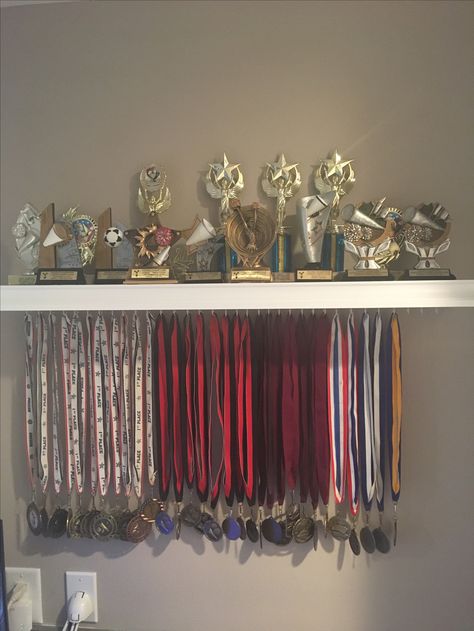 Medal and trophy display. Trophy Stand Design, Medals And Trophy Display Ideas, Football Medal Display Ideas, Medal Picture Ideas, Cheer Trophy Display Ideas, Trophies And Medals Aesthetic, Dance Trophy Display Ideas, Dance Medal Display Ideas, First Place Medal Aesthetic