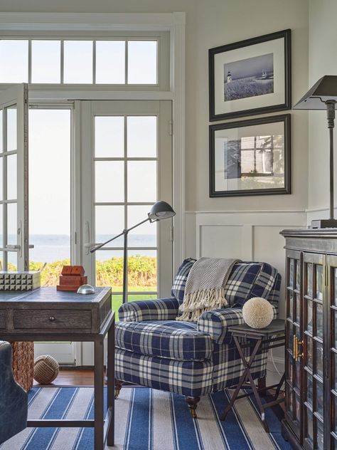 French doors, a cozy plaid armchair, a blue and white striped area rug, and framed black and white art prints complete the refined look of this coastal home office. Maine Interiors, Plaid Armchair, Coastal Home Office, Black And White Art Prints, Seaside Home, Striped Area Rug, Coastal Maine, Plaid Decor, Sea Decor