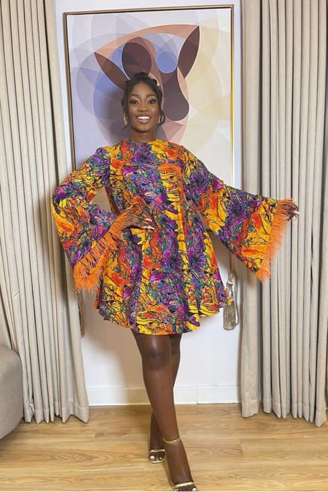 A lady wearing an Ankara fur gown A Line Short Gown Ankara, Fled Gown Ankara, Lastest Style For Materials Short Gown, Short Flare Ankara Gown, Flare Ankara Gown Styles, Ankara Short Flare Gown Styles, Ankara Short Gown Styles 2023, Flare Gown Ankara, Short Flare Gown Styles