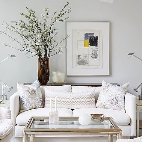 Looking for a creative way to fill the blank wall space behind your sofa? Try adding a narrow console table between the wall and your sofa, then place a tall vase on the table filled with large branches of apple or cherry blossoms and position it adjacent to a generously sized piece of art or frame. The result is whimsical and dramatic, plus it's a great alternative to a gallery wall. #AtHomeSarahStyle (photo: @staceysnaps) @simonschusterca @simonandschuster www.sarahrichardsondesign.com Wall Behind Sofa, Wall Behind Couch, Console Table Behind Sofa, Sofa Table Decor, Table Behind Couch, Couch Ideas, Behind Couch, Sarah Richardson, Sofa Wall