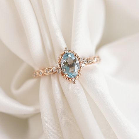 ♥ Carly Allow this vintage-style Aquamarine engagement ring to inspire you with its creative ode to Old World elegance. This beautiful ring features a sparkling cascade of diamonds gracefully nestled around the oval Aquamarine center, amplifying this ornate design. Embrace the look of effortless femininity coupled with a statement of sophistication that will not go unnoticed. The slender, slightly rounded band allows this intriguing ring to lay centered on any finger of your selection when worn. Aquamarine Engagement Ring Rose Gold, Vintage Aquamarine Ring, Aquamarine Wedding Ring, Aquamarine Ring Vintage, Aquamarine Wedding, Wedding Ring Vintage, Engagement Ring Platinum, Cute Engagement Rings, Aquamarine Engagement Ring