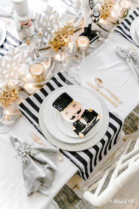 White, gold, and black nutcracker Christmas table decorations for a glam Christmas table. Includes nutcrackers for the center of the table as well as nutcracker plates, glitter snowflakes, snowflake napkin rings, velvet table runner, and gold flatware. #ABlissfulNest #Christmastable #Christmasdecor Black White Christmas Table Decor, Black White And Gold Christmas Table Decor, Nutcracker Christmas Tablescape, Black And White Christmas Table, Nutcracker Christmas Table Decor, Elegant Christmas Table Settings, Black And White Nutcracker Christmas, Black And White Christmas Table Decor Place Settings, Christmas Dessert Table Ideas