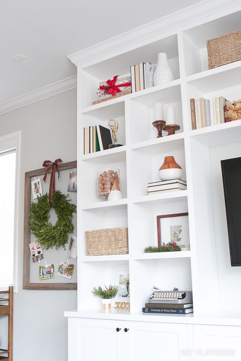 We're sharing our tried and true tips to decorate your shelves for the holidays. You don't need to spend a ton of money to inject some festive touches. Make your home look festive for the Christmas season with these easy styling tips #holidaydecorating #Christmasdecor #shelfie Decorating Bookshelves For Christmas, Decorating Built In Shelves, Style Bookshelf, Neutral Glam, Style Shelves, Dnevna Soba, Decorating Bookshelves, Diy Playbook, Decorating Shelves