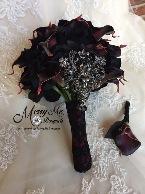 A new twist on this bouquet design uses Black silk roses and dark Plum calla lilies with a statement brooch in Black. The handle is wrapped in Burgundy satin and Black lace. I love this one #blackbouquet #plumbouquet #uniquebouquet #custombouquets #bouquets Black And Burgundy Gothic Wedding, Gothic Wedding Flowers Bridal Bouquets, Dark Chapel Wedding, Black And Plum Wedding, Burgundy Black Wedding, Burgundy And Black Wedding, Black And Burgundy Wedding, Dark Bouquet, Cala Lilies