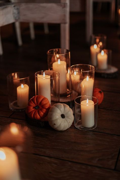 Boho wedding with autumnal wedding decor including pilar candles in hurricane vases and mini orange and white pumpkin decorations for the aisle Candle And Pumpkin Wedding Centerpieces, Autumn Pumpkin Wedding Decor, Fall Wedding Altar Decor, November Wedding Simple, Simple Fall Boho Wedding Decor, Mini Pumpkin Wedding Decor, Fall Beach Wedding Table Decor, Fall Centerpieces Wedding Pumpkin, Fall Wedding Pumpkin Decor