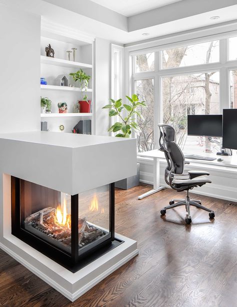 A low three-sided fireplace acts as a room divider separated the living room from the home office. Small Double Sided Fireplace, Triple Sided Fireplace, Room Divider Fireplace, Three Sided Fireplace Ideas, Fireplace Room Divider, Three Sided Fireplace, Home Office Area, 3 Sided Fireplace, House Fireplace