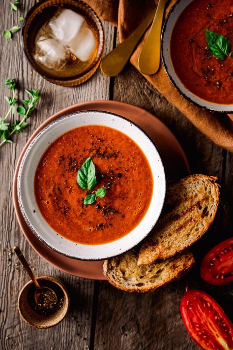 Overhead of Roasted tomato soup in a bowl topped with basil, pepper and served with grilled bread Soups Photography, Tomato Soup Photography, Soup Photography Styling, Soup Pictures, Tomato Photography, Soup Photography, Tomato Soup Grilled Cheese, Holiday Soups, Bell Pepper Soup