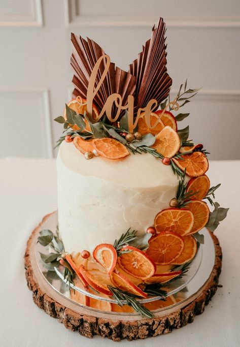 Wedding Cake with White Frosting and Dried Oranges and a cake topper that says 'Love' on a silver and tree trunk plate Orange Wedding Color Palette, Fall Cake Toppers, Autumn Wedding Cakes, Orange Wedding Cake, Olive Green Bridesmaid Dresses, Orange Wedding Themes, Orange Wedding Colors, Orange Wedding Invitations, Orange Bridesmaid