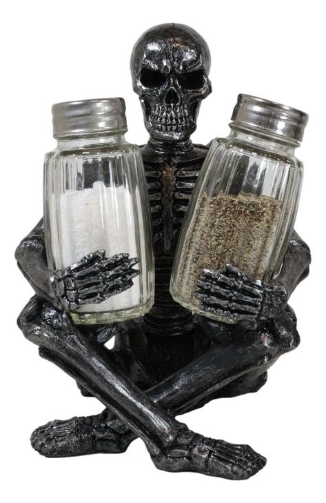 PRICES MAY VARY. This Grinning Skeleton Salt Pepper Shakers Holder figurine set is 6.25" tall, 4.5" long and 4" deep each approximately. This Grinning Skeleton Salt Pepper Shakers Holder figurine set is made of designer composite resin, hand painted and polished. Color Tone may vary. Glass shakers included but the condiments are not. Add a fun dash of fright to every meal with this seriously spooky grinning skeleton salt and pepper shaker set. Intricate detailing gives it a spine chilling and re Skull Kitchen Decor, Spooky Apartment Decor, Alt Kitchen, Vampire Kitchen, Goth Apartment Decor, Halloween Interior Decor, Sitting Skeleton, Gothic Kitchen Decor, Skull Furniture