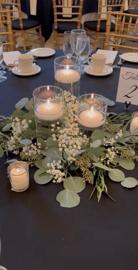 No Flowers Centerpieces Wedding, Dusty Blue Flowers Centerpieces, Low Eucalyptus Centerpiece, Floating Candle Centrepiece, Candle Table Arrangements, Vases And Candles Centerpieces, Inexpensive Round Table Centerpieces, Simple Affordable Wedding Centerpieces, Greens And Candles Centerpieces