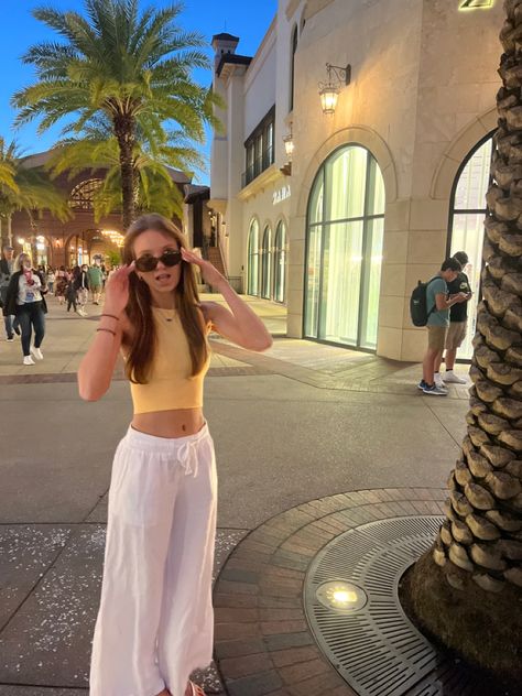 orange high neck top with white flowy pants Orlando Outfits Spring, Disney World Florida Outfits, Vacation Outfits Florida Disney, Orlando Summer Outfits, Disneyland Aesthetic Outfit Summer, Disney Springs Outfits, Disney World Florida Aesthetic, Disney Springs Instagram Pictures, Dinner Night Outfit