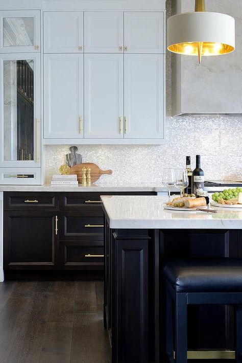 White and brown kitchen features white upper cabinets and espresso stained lower cabinets adorned with long brass pulls paired with white quartz countertops and a white iridescent tile backsplash. White And Brown Kitchen, White Upper Cabinets, Backsplash With Dark Cabinets, Espresso Kitchen Cabinets, Iridescent Tile, Espresso Kitchen, Brown Kitchen Cabinets, Brown Cabinets, Brown Kitchen