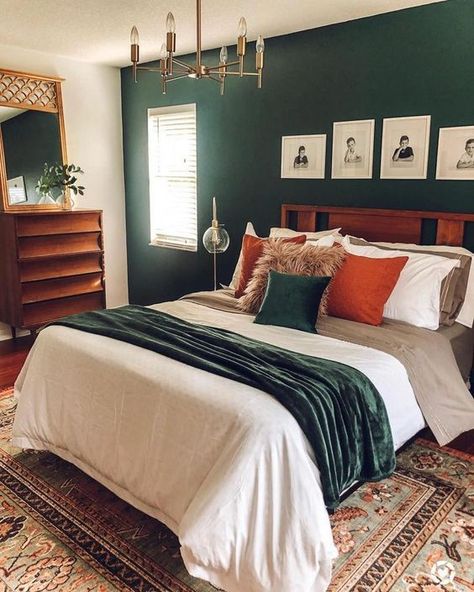 a mid century modern bedroom with a dark green accent wall, a stained bed and dresser, a gilded chandelier, bright bedding and a mirror in a gilded frame Emerald Green Bedrooms, Dresser Bedroom, Green Accent Walls, Decor Mirror, Bedroom Orange, Dekorasi Kamar Tidur, Green Walls, Bedroom Dresser, Bilik Tidur