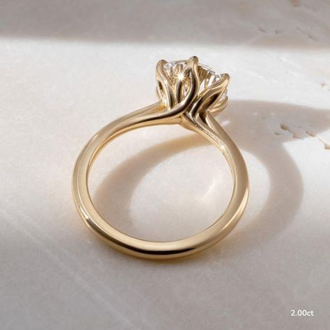 This 2 carat lab grown yellow gold elswin twisted flower engagement ring elevates and enhances the round brilliant cut diamond in a way in which this simple claw prong solitaire features an open basket with six elegant leaves that cradle the center diamond. Handcrafted in Hatton Gardens, London.  ... daha fazla Claw Engagement Ring, Flower Engagement, Solitaire Engagement Rings, Dragon Claw, Minimalist Engagement Ring, Flower Engagement Ring, Claw Prong, Diamond Solitaire Rings, 2 Carat