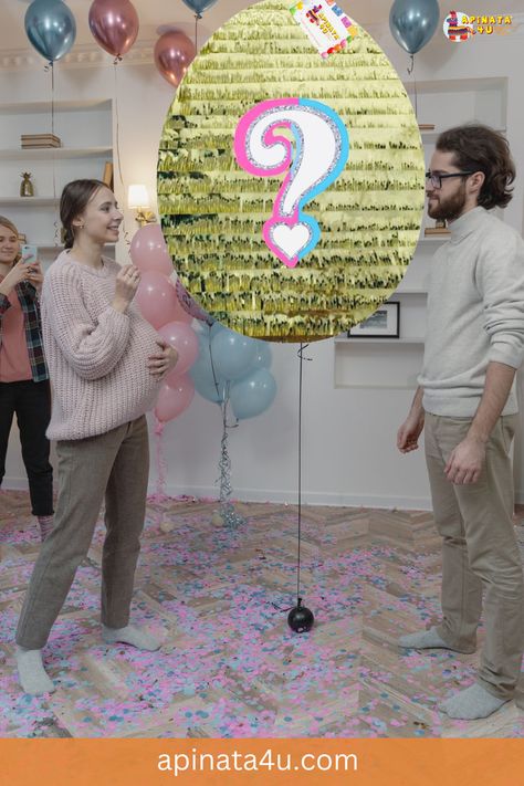 A couple celebrating a gender reveal party faces a large golden egg piñata with a colorful question mark on it. The floor is sprinkled with pink and blue confetti, and balloons in similar colors float behind them. The pregnant woman smiles while holding her belly, and a friend is taking photos in the background. Easter Gender Reveal, Unique Gender Reveal, Easter Theme Party, Cute Questions, Gender Reveal Unique, Reveal Party, Accessories Ideas, Easter Sunday, Question Mark