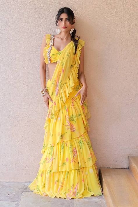 Yellow ruffle pre-draped saree with an attached cancan and floral print. Comes with a padded blouse with cowrie and thread hand embroidery. - Aza Fashions Ruffle Saree Lehenga, Printed Drape Saree, Modern Saree Outfit, Drape Ruffle Saree, Haldi Ruffle Saree, Yellow Saree Design, Ruffle Saree For Haldi, Designer Yellow Saree, Yellow Frill Saree For Haldi