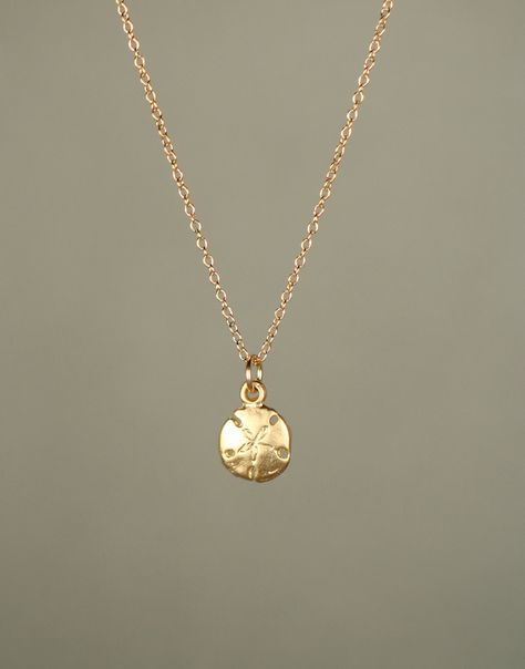 Gold sand dollar necklace - delicate necklace - a tiny 14k gold vermeil sand dollar hanging from a 14k gold filled chain A tiny 14k matte gold vermeil sand dollar hangs from a 14k gold filled chain in the length of your choice.  Please feel free to select a different length if you prefer!  I can also make a set of matching dangling earrings if you like.  Now available in sterling silver!  This tiny sand dollar measures 8mm. Looking for an ever so slightly bigger sand dollar? https://www.etsy.com Sand Dollar Earrings, Sand Dollar Necklace, Button Piercing, Beachy Jewelry, Preppy Jewelry, Gold Sand, Jewelry Accessories Ideas, Gold Overlay, Jewelry Essentials