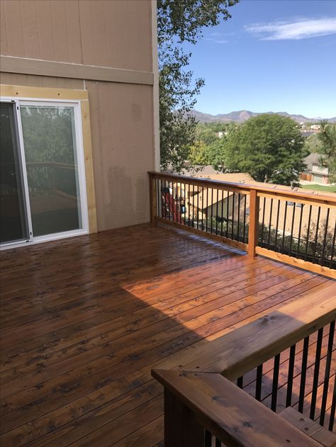 Cedar deck stained in Superdeck Canyon Brown. Cedar railing with black aluminum balusters. Cedar Deck With Black Railing, Brown Deck Black Spindles, Stained Deck With Black Spindles, Canyon Brown Deck Stain Sherwin Williams, Deck Stain With Black Railing, Trending Deck Stain Colors, Walnut Stained Deck, Superdeck Stain Colors, Deck Stain Colors For Tan House