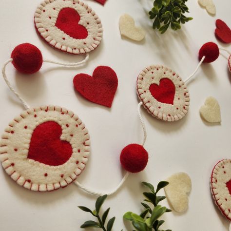 "~Valentine Sugar Cookies Heart Garland~ Cute felt garland made with love! Created by me, @lazystitch ♥PRODUCT~ Felt cute handstitched sugar cookie heart garland! Perfect for décor to spruce up your home, event, or office! I designed and 100% hand sewn by me! Garland is ready to hang! Each handstitched piece are handmade unique to each other. *13 MOVABLE PIECES*  ♥LENGTH - Approx: 57.5\" inches (trimmable) Garland Felt Area 46\" inches Felt Balls Measure approximately 1\" ♥SHIPPING~ Ready to shi Valentines Day Felt Garland, Felt Wedding Decorations, Handmade Valentines Decorations, Diy Felt Bunting, Winter Felt Garland, Felt Decorations Diy, Valentines Felt Crafts, Spring Felt Crafts, Valentine Felt Crafts