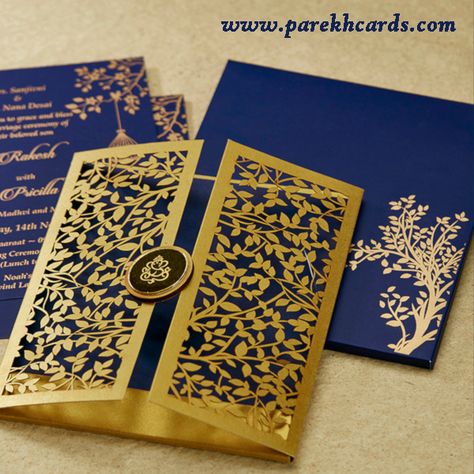 The invitation card is made out of high quality Blue paper board with matching mailing box envelope and coordinated inserts inside. Card front has a beautiful golden tree laser cut design with rich style of Door opening. Card front also has round wooden lasercut pasteup in center with Gold plated Ganesh paste-up on top. Royal Invitation Card Design, Hindu Wedding Invitation Cards Indian Style, Kankotri Designs, Hindu Wedding Card Design, Speakeasy Invitations, Golden Invitation, Wedding Card Format, Opening Card, Hindu Wedding Invitation Cards