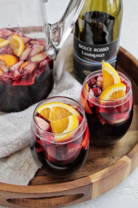 two glasses of sangria in wine glasses. Winter Sangria Recipes Red, Lambrusco Sangria, Holiday Cocktails Thanksgiving, Winter Sangria Recipes, Superbowl Cocktails, Sparkling Sangria, Tequila Soda, Red Sangria Recipes, 15 Taylor Swift