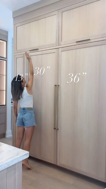 Laura Rustico II Building Beauty Full on Instagram: "You can really tell how short I am in this one 🙈

🤩Sharing our fridge / freezer panelled cabinetry wall. 

One thing I truly love about this wall is the 13” cabinet next to the fridge. It has become our go to place for snacks, everyday essentials and the kids love the easy access. 

I store away seasonal decor in the top two cabinets which include a single pull hardware and lift upwards for some design variety. 

Our fridge and freezer are panelled and overall, I’m really happy with choosing to panel them. I love waking up to the white oak look. 🍃

Here are the full dimensions

Panelled Freezer - 30” x 80”
Panelled fridge - 36” x 80”
Side cupboard- 13” x 80”
Upper lift Cabinets- 46” x 24”

All hardware is linked via https://liketk.it/ Diy Panel Fridge, Refrigerator Wall With Cabinets, How To Hide Deep Freezer, Hiding Deep Freezer, Panelled Fridge, Above Fridge Ideas, Hidden Fridge, Side Cupboard, Above Fridge