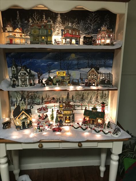 Christmas Village with backgrounds I painted on foam board. Christmas Village Bookshelf Display, Background For Christmas Village, Christmas Village Hutch Display, Christmas Village Bookshelf, Christmas Village Backdrop Ideas, Christmas Village On Mantle, Christmas Village Background, Christmas Village Display Ideas Layout, Christmas Village Backdrop