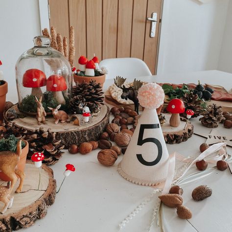 Woodland birthday set up display on a white table. Using pine cones, log cuts, moss, glass dome and toy woodland animals Toadstool Party Decorations, Mushroom Woodland Party, Mushroom Second Birthday, Woodland Birthday Decor, Woodland Mushroom Birthday Party, Toadstool First Birthday, Fall Woodland Birthday Party, First Birthday Outdoor Theme, Mushroom Forest Party