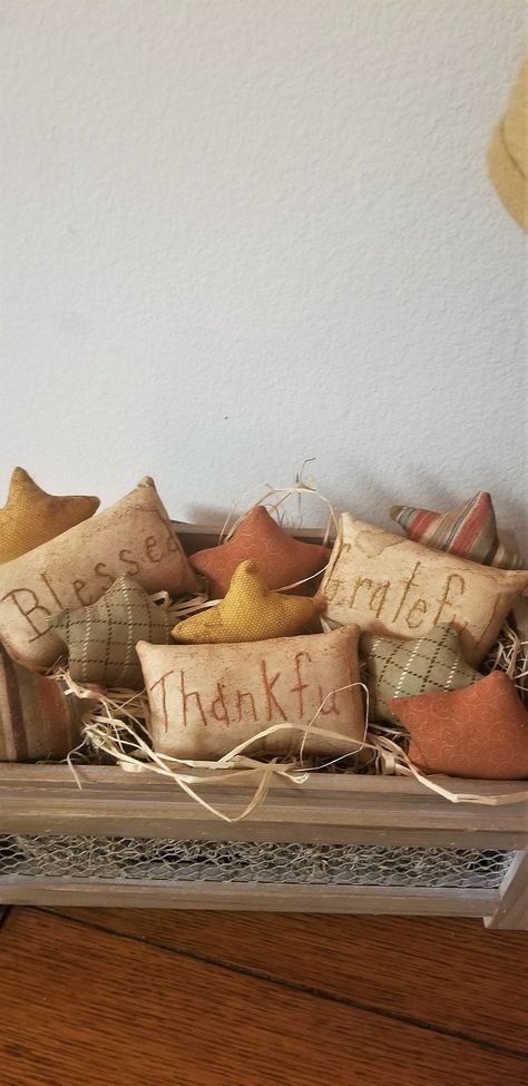 "How cute are these prim Thanksgiving bowl fillers? They have great Fall colors in the stars and muslin pillow tucks with the words, \"Thankful, Blessed, and Grateful\". Just pop them in any bowl, crate, or metal plate and have a great centerpiece for the Fall and Thanksgiving season. You will get 8 star bowl fillers, all fall fabrics. You will also get 3 muslin pillow tucks with the words, Grateful, Blessed, Thankful hand stitched in Fall colors. All the items have been hand stitched, sewn, and Bowl Filler Pillows, Winter Bowl Filler, Bowl Fillers Diy, Diy Bowl Fillers, Thanksgiving Bowl, Fall Bowl Fillers, Muslin Pillow, Primitive Fall Decorating, Primitive Thanksgiving