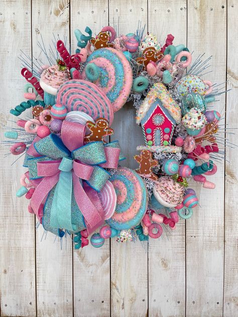 "Christmas Winter Holiday Gingerbread House Candy Pink and blue wreath for your front door porch entrance entryway wall hanging home decor, gift idea. Completed wreath Measures approximately 26\"(W) x8\"(D). Flocked Pine wire wreath frame, multi glitter ribbon bow pink & blue, lightweight foam gingerbread house attachment, various candies and lollipops cupcakes glitter accents. **Indoor/Outdoor but for best longer lasting results display in a covered or protected area. Over time exposure to sun Candy Theme Christmas Wreath, Christmas Candy Wreaths Diy, Candy Land Christmas Wreath, Candy House Decorations, Blue And Pink Christmas Decor, Candy Wreath Diy, Gingerbread House Pink, Pink And Blue Candy, Pink Blue Christmas