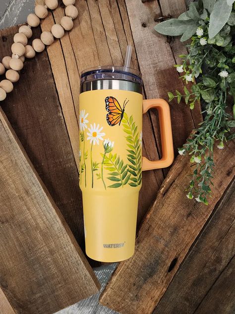 Get ready to elevate your sipping experience with this limited-edition collection!  Each 40oz tumbler with handle is a handpainted floral design that will make you stand out from the crowd.  Each cup is sanded, painted, and sealed with coats of matte spray.   "Fly High" is vinyl along bottom. This tumbler works great f