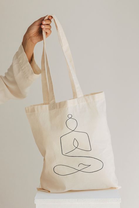 Inspired by my love for yoga and the planet, this tote has been printed with my yoga line drawing and would make a perfect gift for a eco-conscious yoga or meditation lover. As well as being made from 100% organic cotton, it is also vegan-friendly, printed with water-based inks and delivered in plastic-free packaging. This tote is lightweight but durable with a double-folded top and reinforced twin handles for added strength and durability. Machine was at 30oC. OOO Organic cotton tote bag Yoga meditation gift Eco friendly shopping bag Minimal bag for life Beige reusable shopper Vegan approved tote bag OOO WHEN ORDERING PLEASE NOTE FOLLOWING- *Colors may differ slightly from what you see on your screen due to monitor calibration settings. *Having been freshly printed with my design please e Yoga Line Drawing, Minimal Bags, Yoga Tote Bag, Yoga Tote, Eco Friendly Shopping Bags, Meditation Gifts, Yoga Bag, Yoga Gifts, Personalize Bag