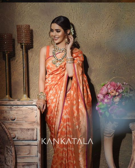 Sana Sayyad radiates in orange this saptami as she drapes herself in our handpicked Orange Banarasi Silk Jaal saree from Daivatvam Collection. The vibrant orange body of the handwoven silk is enamoured with gold zari kadwa jaal that Banarasis are known for. The self border features floral vines whereas the self pallu that sana flaunts glistens with gold zari brocade. #Daivatvam #9colorsofdivinity #mahagauri #festiveedition #navadurgaseries #weavesofindia #heritageweaves Banarasi Sarees Silk, Orange Benaras Saree, Orange Colour Pattu Saree, Orange Wedding Saree, Benaras Silk Sarees, Orange Bridal Saree, Orange Saree Look, Orange Pattu Saree, Banarasi Silk Saree Bridal