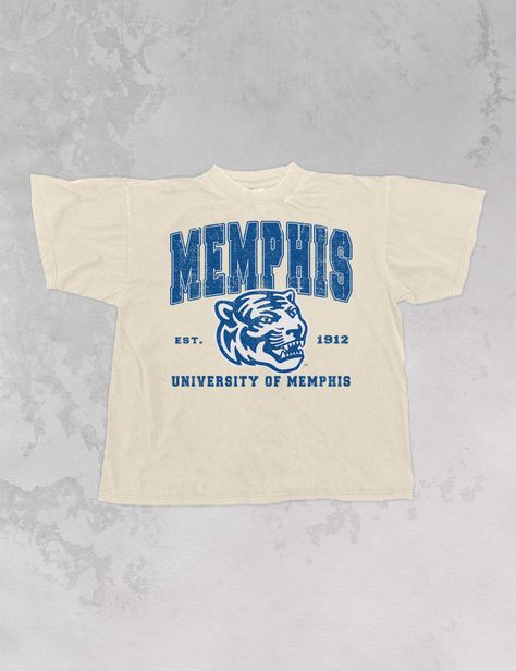 **Officially licensed with the University of Memphis** Show the love for your favorite team in our one and only Memphis University Tigers oversized 90's t-shirt. - Features Memphis in all caps above the official Memphis Tigers logo and est. 1912 to the side, University of Memphis below all in a blue and white ink - Screen print transfer that is heat pressed onto each tshirt - Tshirt is a super soft vintage wash that gets softer after each wash- Oversized fit- Sizing translation: XS/S - L , S/M - XL , L/XL - 2XL , 2XL/3XL - 3XL - Model is 6'1" wearing a size S/M * colors may vary slightly due to screens and filters * University Tees Design, Alumni Tshirt Design Ideas, Vintage College Aesthetic, University Shirt Design, College Tshirt Designs, 90s Tshirt Design, College Team Shirts, College Shirt Design, School Tshirt Designs